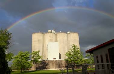 Grey sky with rainbow over 4 Lafarge Brookfield Silos